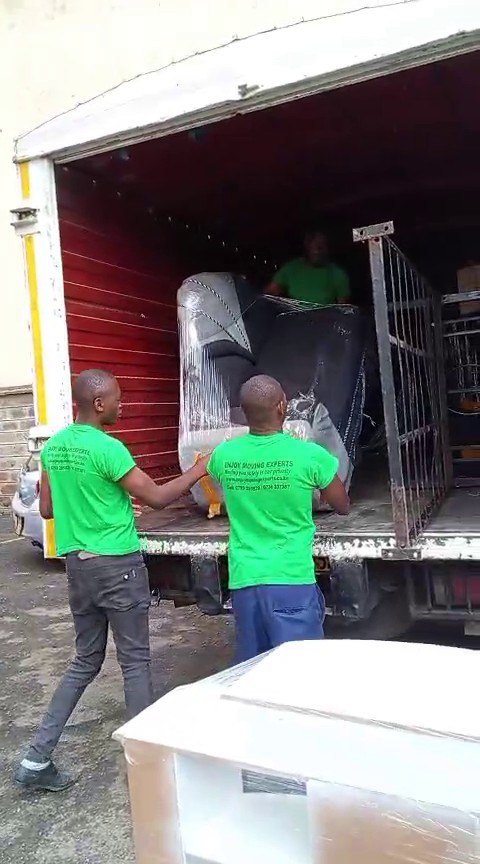 Crew loading wrapped household items into the moving truck